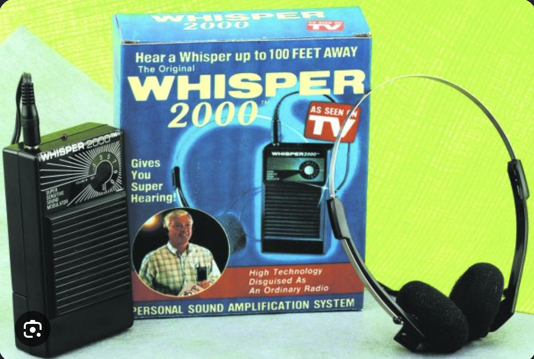 Whisper 2000 sound amplifier, headphones and original blue retail box against a green background