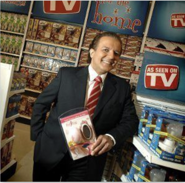 AJ Khubani holding a product in front of shelves and As Seen on TV signage